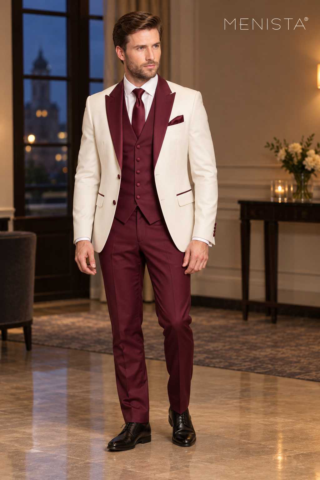 Front view of Menista ivory three-piece suit with burgundy peak lapels, five-button waistcoat and burgundy trousers.