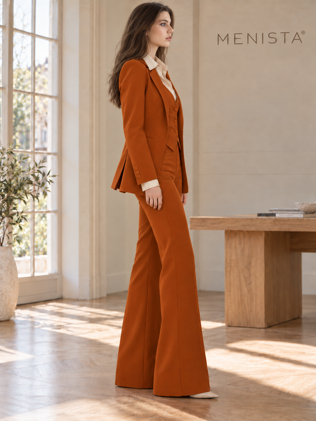 Sofia wearing women’s burnt-orange jacket, four-button waistcoat and matching flared trousers, side view.