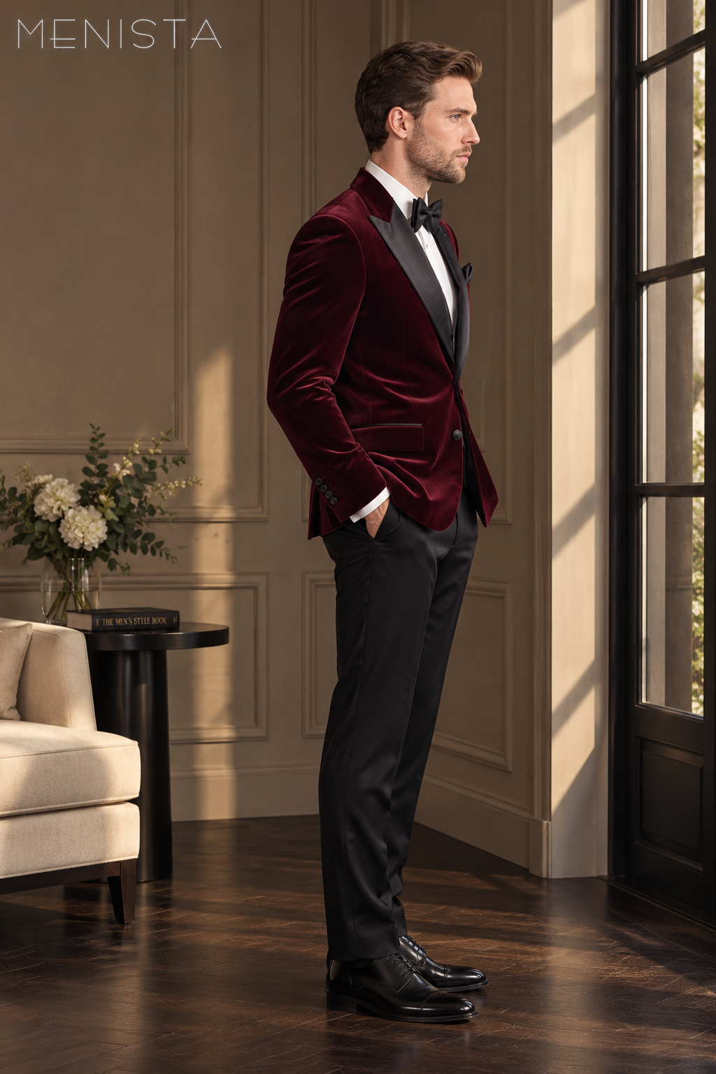 Side view of Menista maroon velvet jacket showing tailored drape, black peak lapels and black trousers.