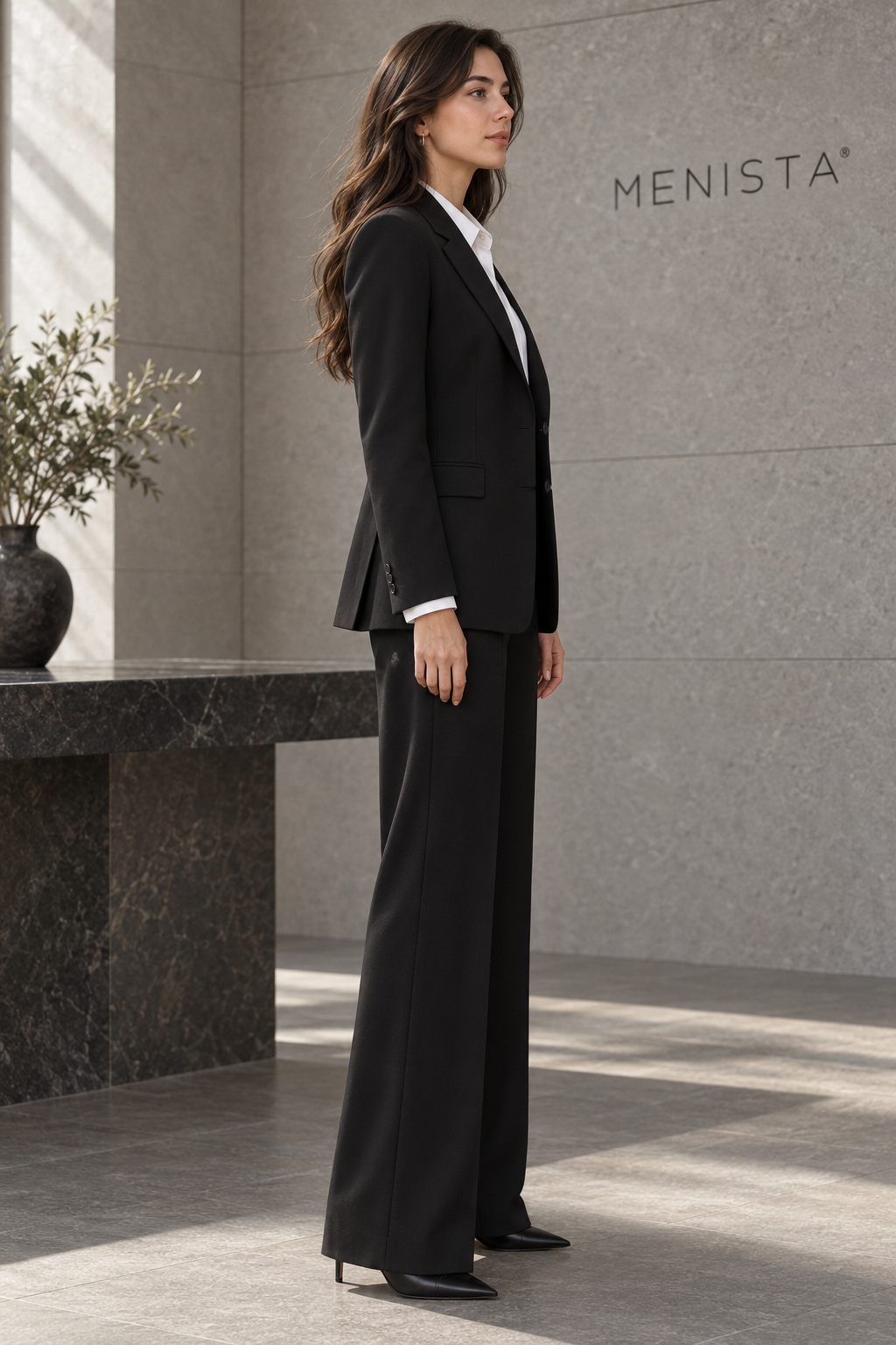 Side view of women’s black two-button jacket and matching wide-leg trousers.