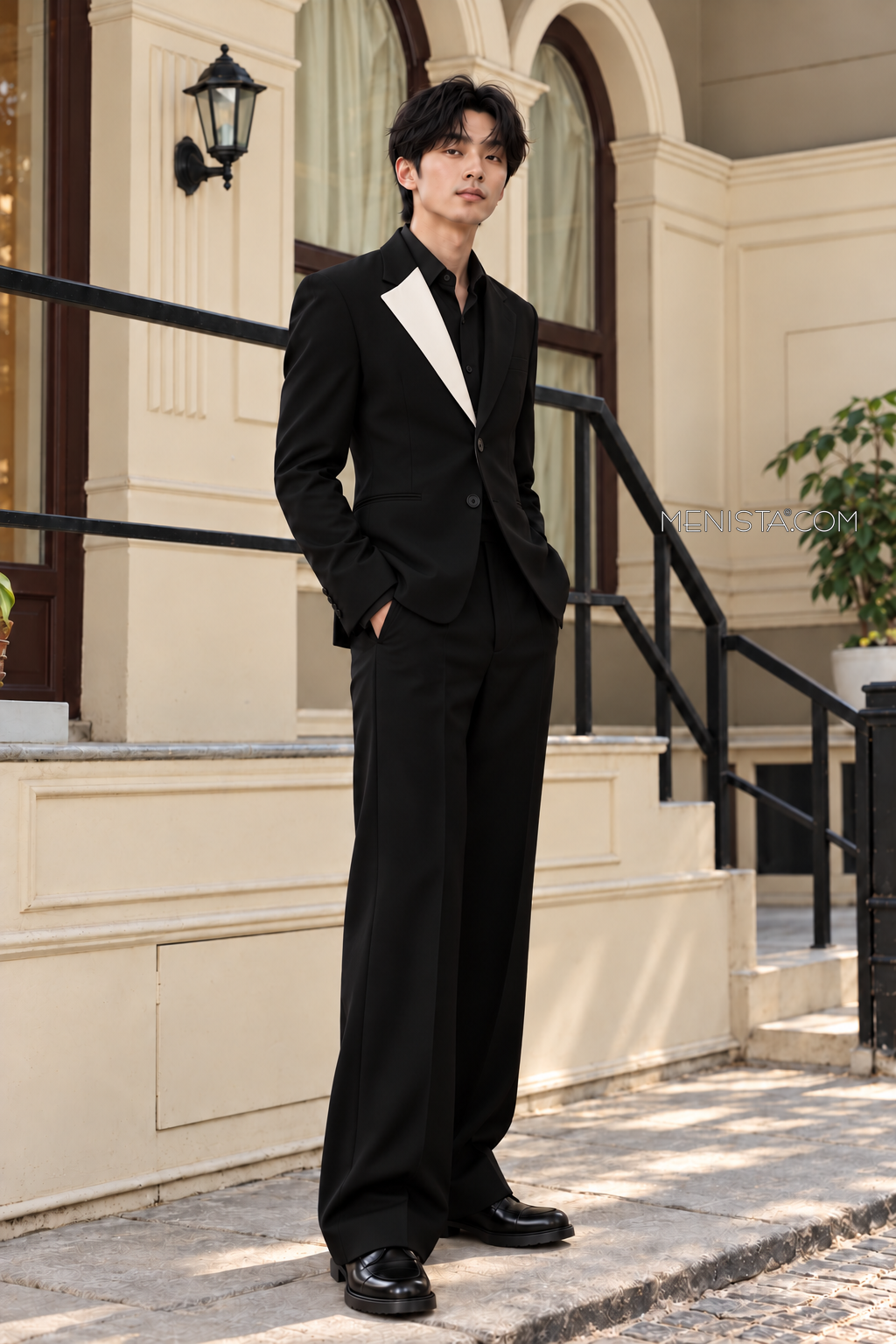 Caldric black and ivory two-button suit on Kevin, three-quarter view with wide straight-leg trousers.