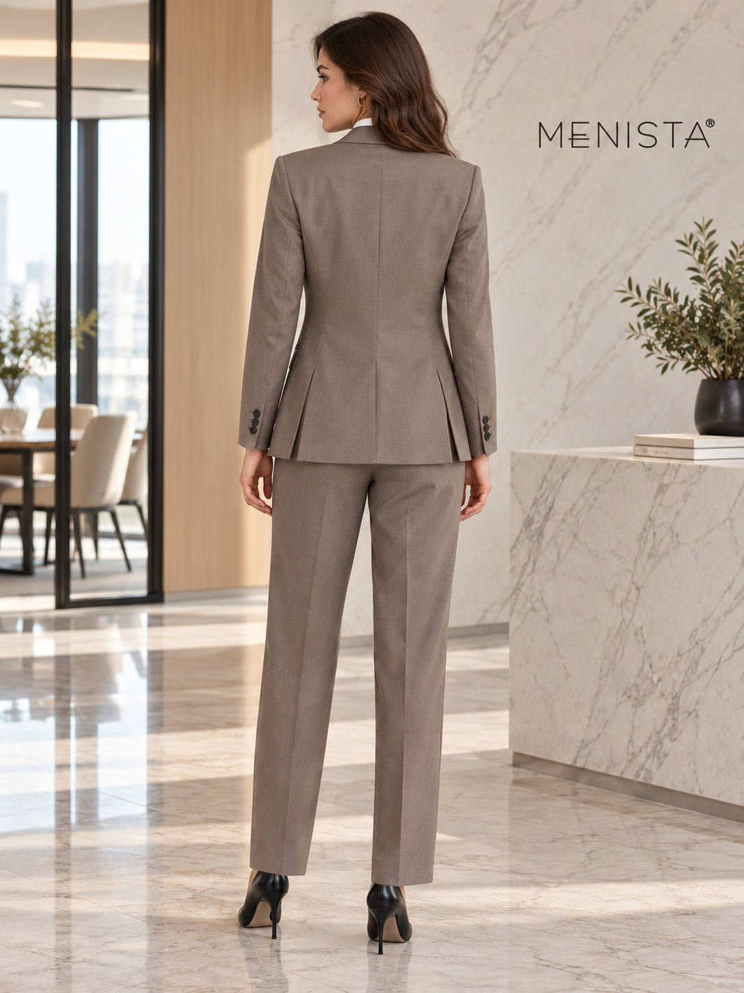 Rear view of women’s taupe three-piece suit with full-length straight-leg trousers and twin jacket side vents.