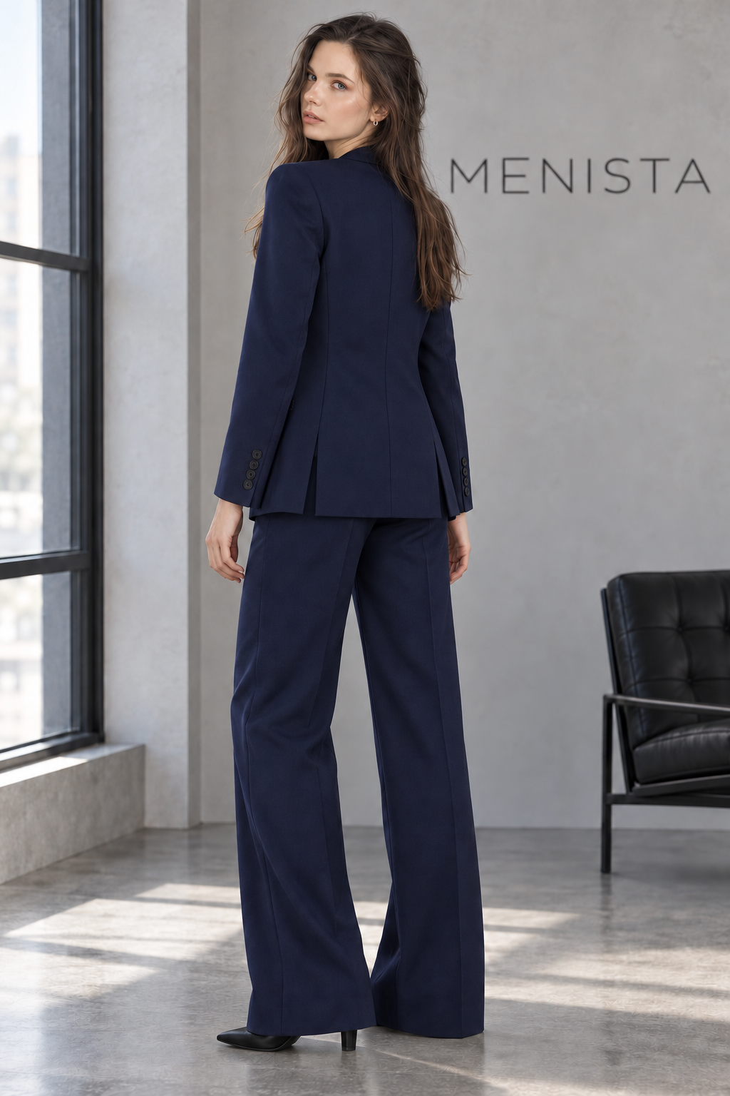 Back view of the navy women’s blazer with twin side vents, a closed center hem and matching trousers.