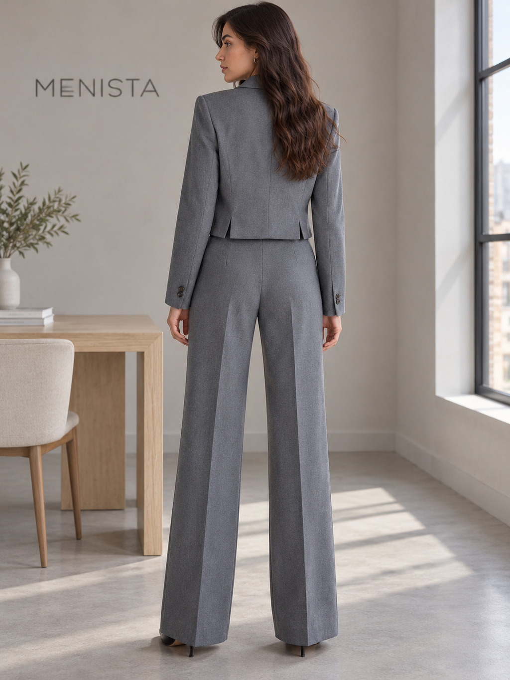 Rear view of women’s grey cropped single-button blazer and matching wide-leg trousers, showing the jacket’s twin side vents.