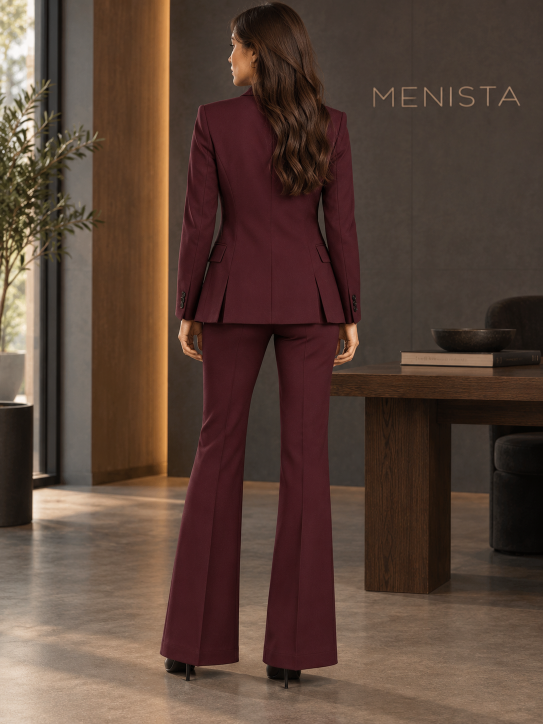 Rear view of women’s burgundy single-button jacket and matching flared trousers, showing the jacket’s twin side vents.