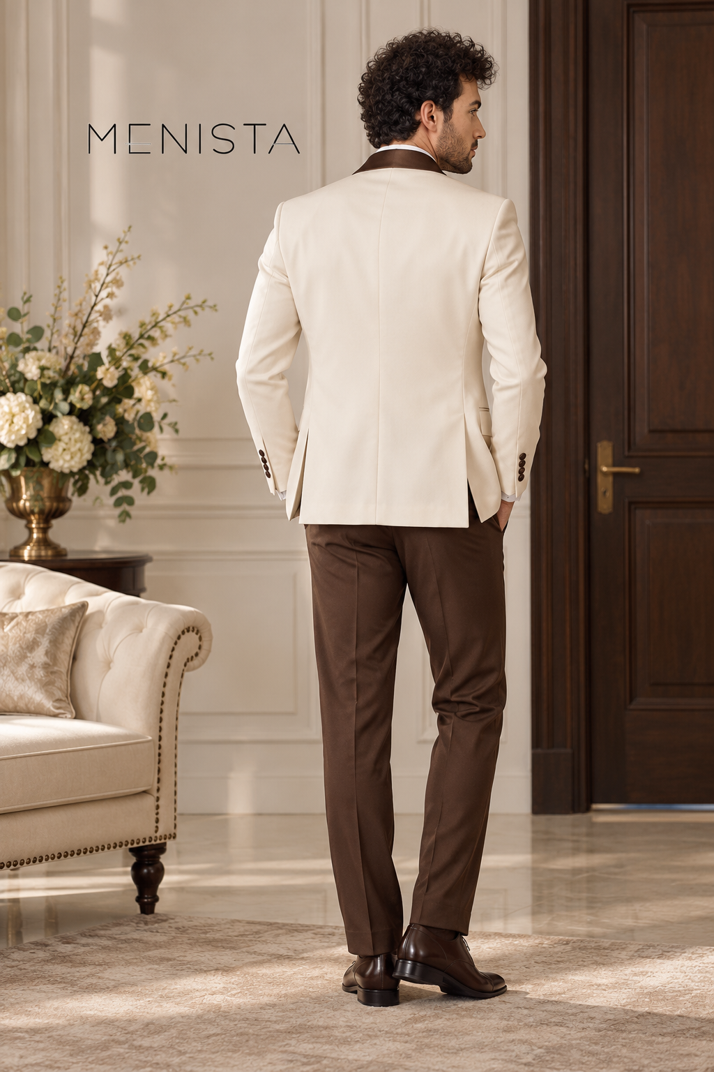 Back view of Menista ivory suit jacket with twin side vents, showing shoulder fit, jacket length and brown trousers.