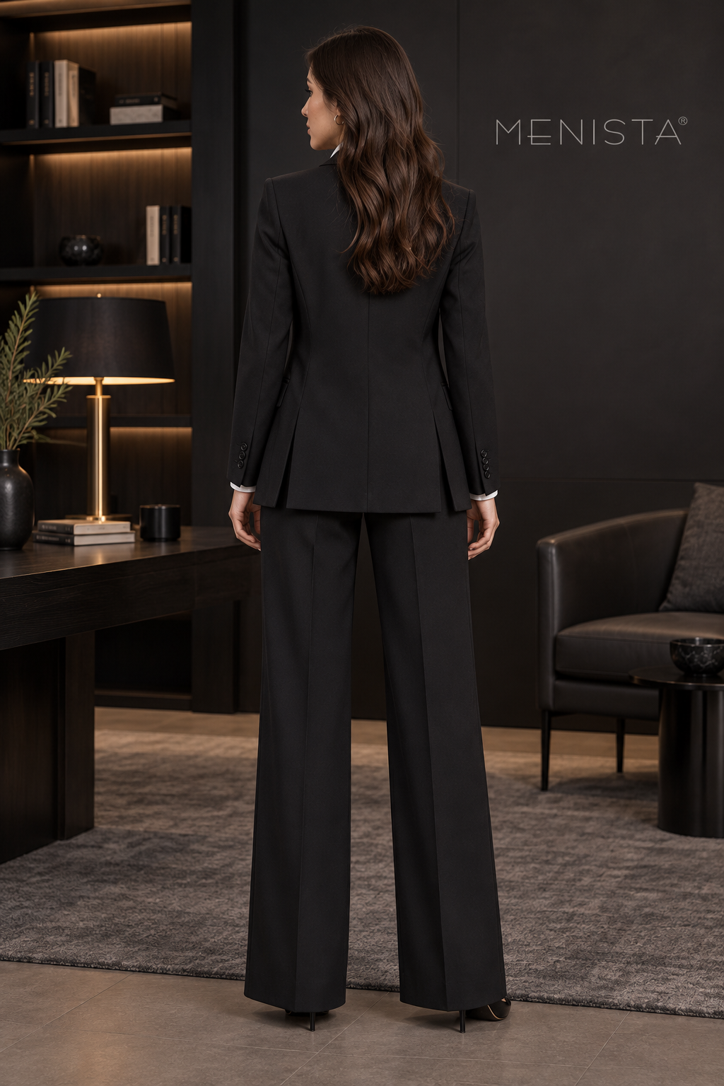 Rear view of women’s black notch-lapel jacket, four-button waistcoat and matching wide-leg trousers, showing the jacket’s twin side vents.