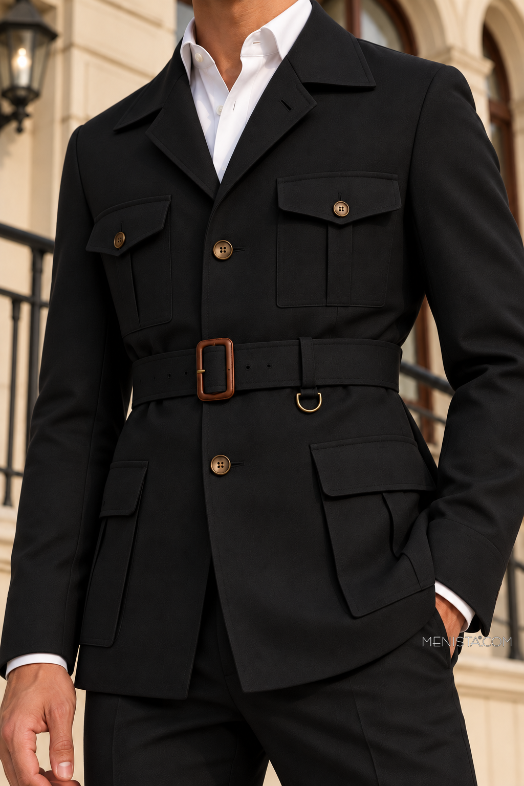Close-up of Auberon’s plain black hunter jacket, patch pockets, buttons and brown buckle waist belt.