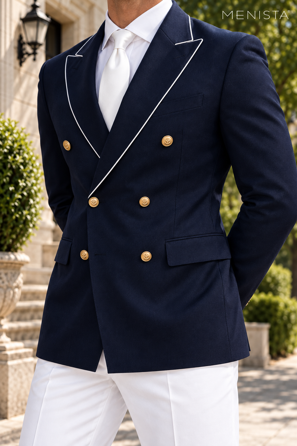 Close-up of navy peak lapels with fine white piping and six gold metal front buttons.