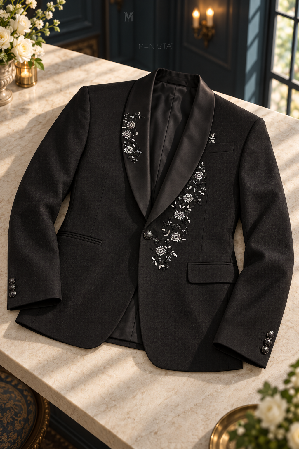 Dorian black daisy embroidered jacket laid flat, showing silver floral vines, satin shawl lapels and pocket construction.