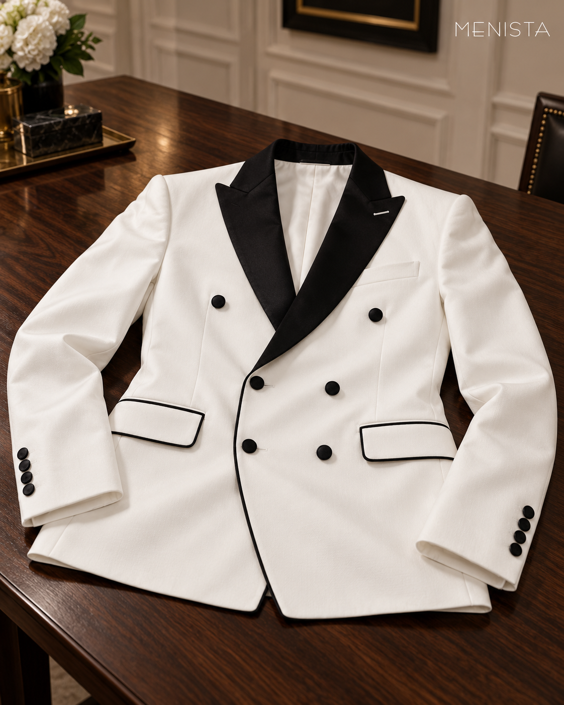 Menista white double-breasted tuxedo jacket laid flat, showing black peak lapels, six buttons, black piping and sleeve construction.