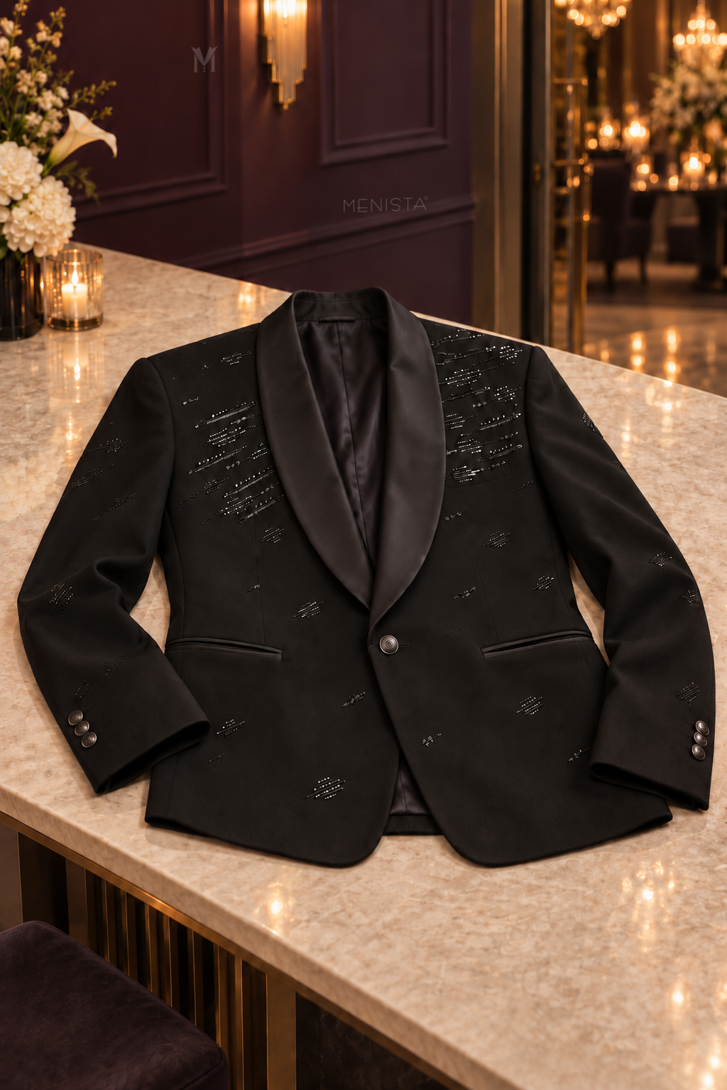Noctis black beaded jacket on a flat stone tabletop with satin shawl lapels, two jetted pockets and three cuff buttons.