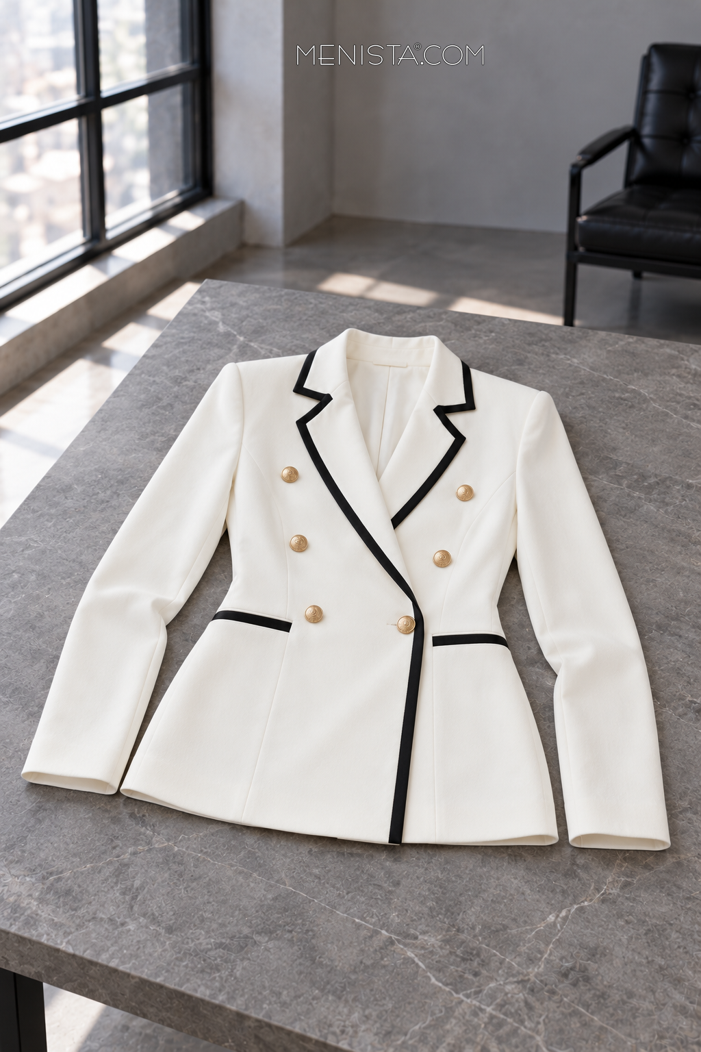 Vespera ivory and black jacket spread flat on a stone table, with both sleeves supported.